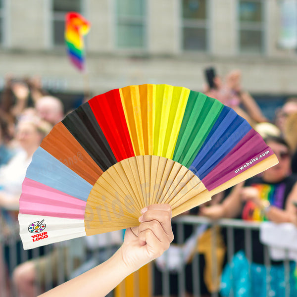 Pride Fans® female holding a large rainbow colored festival clack fan in a gay pride festival